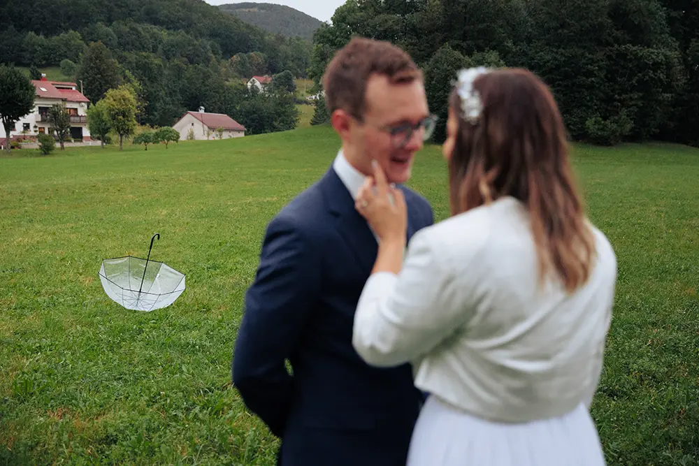 Poročni par stoji na deževen dan v ozadju spuščena marela